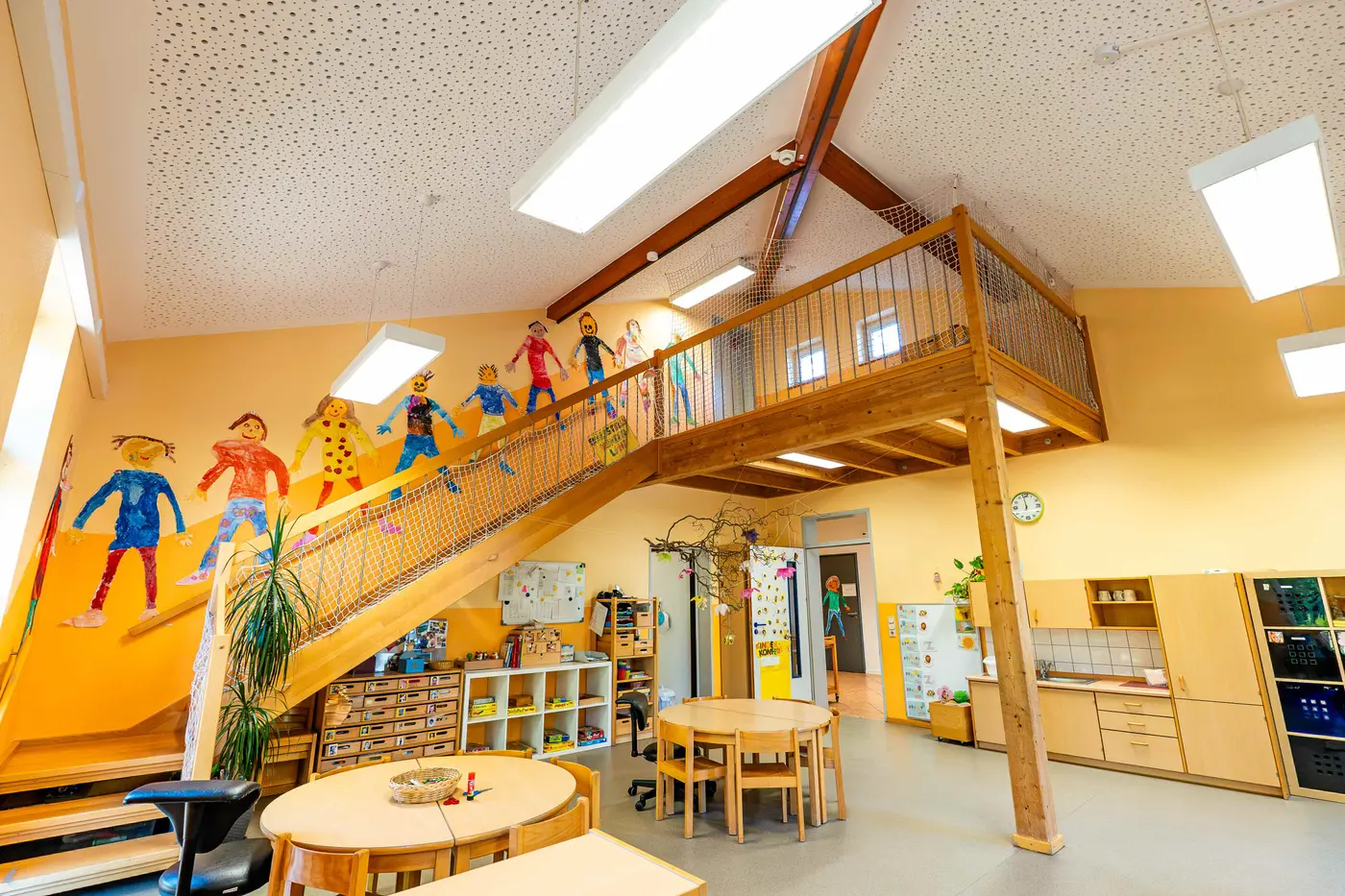 Gruppenraum mit Hochebene und gemalten Kinderfiguren in der Kita Schweich